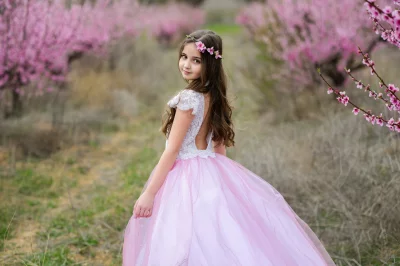 Young Girl in Pink Gown and Flower Wreath in Blooming Peach Orchard image