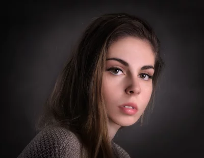 Young Woman Headshot with Long Brown Hair and Contemplative Gaze image