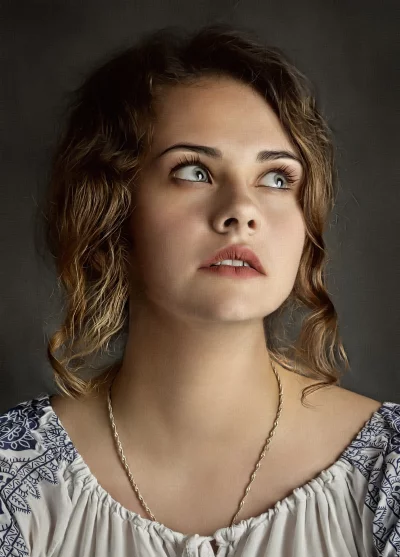 Pensive Young Woman with Expressive Gaze and Wavy Hair Looking Up image