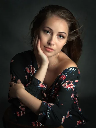 Captivating Young Woman in Floral Top with Pensive Gaze image