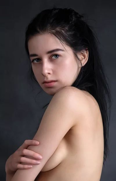 Captivating Young Woman with Dark Hair Posing Bare-chested, Arms Crossed, in Studio image