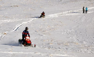 People Enjoying Snowmobiling and Winter Sports on a Sunny Snowy Landscape Adventure image