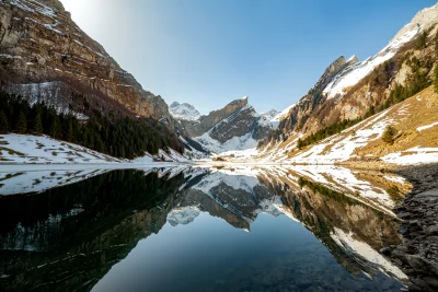 Majestic Swiss Alpine Lake Reflection with Snowy Peaks and Clear Blue Sky image