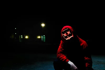 Crouching Figure with Eerie Glowing Red Mask and XX Eyes image