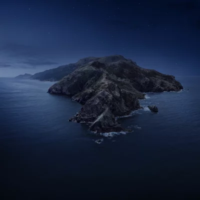 Starry Night Sky Illuminating Remote Rocky Island in Dark Ocean Landscape image