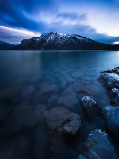 Majestic Twilight Over Snow-Capped Mountain Lake with Icy Rocks image