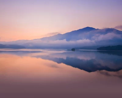Tranquil Lake and Misty Mountains with Sunrise Reflection and Pastel Sky image