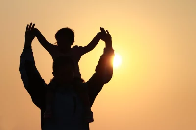 Father and Daughter Silhouettes Embracing Joy at Golden Sunset image