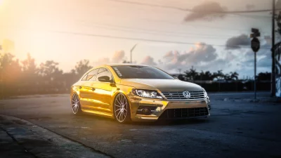 Luxurious Gold Wrapped Volkswagen CC Sedan with Custom Wheels at Sunset image