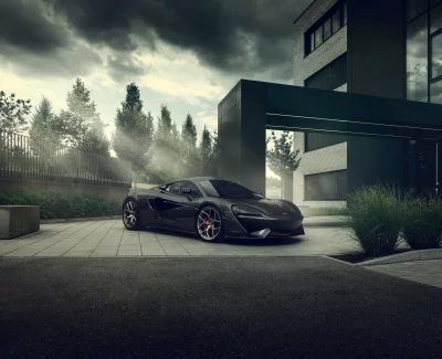 Sleek Dark Grey McLaren Sports Car Parked Under Dramatic Cloudy Sky image