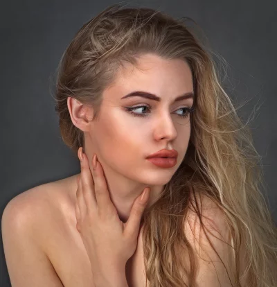 Pensive Woman with Flowing Blonde Hair and Bare Shoulders image