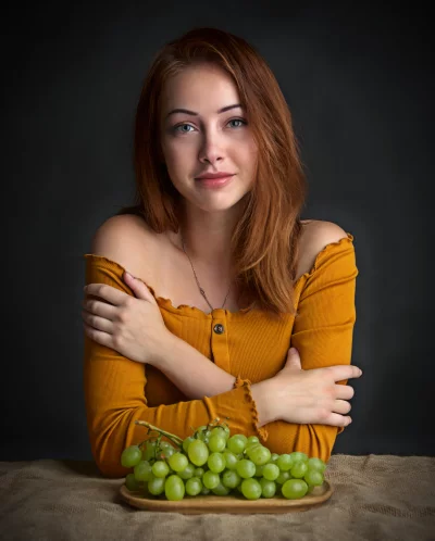 Young Woman Posing with Fresh Green Grapes in Yellow Off-Shoulder Top image