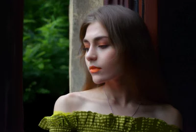 Pensive Young Woman with Orange Makeup and Gingham Top by Window image