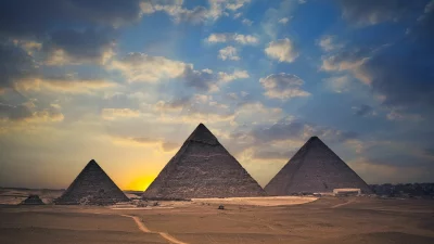 Iconic Pyramids of Giza at Golden Sunset with Radiant Sun Rays and Dramatic Clouds image