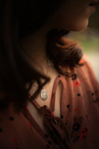 Woman wearing a floral print dress with a delicate necklace