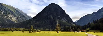 Alpine Mountain Valley Panorama with Cyclists, Village, and Forested Peaks image