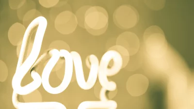 Radiant Neon Love Sign Illuminating Golden Bokeh Background for Romance image