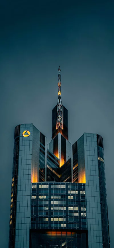 Modern Skyscraper Illuminated at Dusk with Iconic Triangle Logo