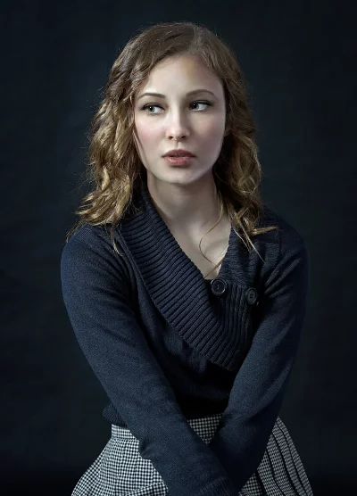 Young Woman with Curly Hair and Pensive Gaze in Studio Portrait image
