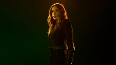 Intense Sci-Fi Heroine in Armored Suit with Dynamic Backlighting on Dark Background image