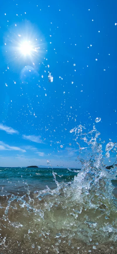 Dynamic Water Splash Against Clear Blue Sky and Shimmering Ocean Under Bright Sun image