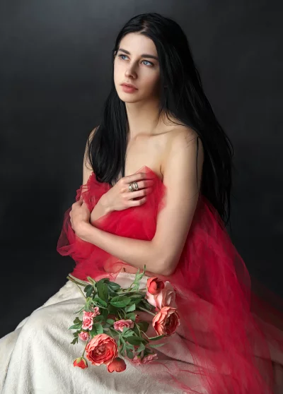 Elegant Woman Draped in Red Tulle with Flowers, Contemplative Gaze image
