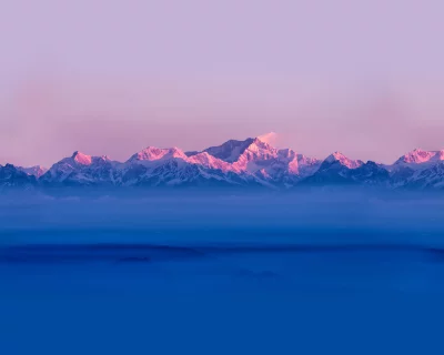 Himalayan Peaks Glowing at Sunrise Over Misty Blue Valley image