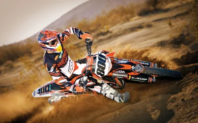 Professional Motocross Rider Cornering Sharply on Dirt Track Kicking Up Dust image