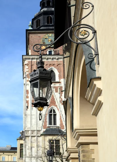 Ornate Black Street Lamp with Historic Clock Tower Background in Krakow image