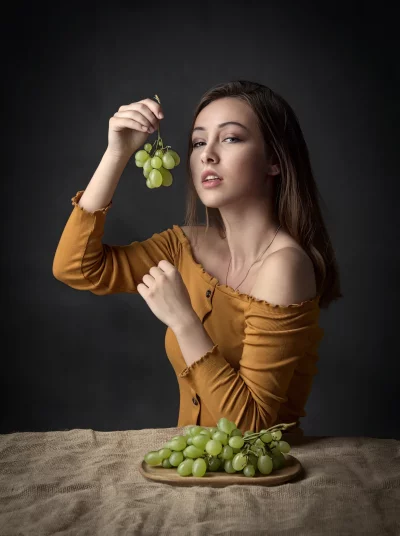 Fashionable Woman Posing with Fresh Green Grapes in Mustard Off-Shoulder Top image