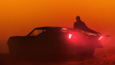 Iconic Superhero Batman and His Batmobile in a Dramatic Orange Desert image