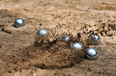 Dynamic Pétanque Boules Striking Sand with Explosive Dust and Action image
