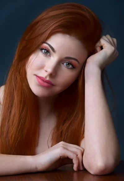 Red-Haired Woman with Pink Makeup and Thoughtful Expression image