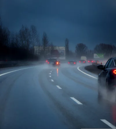 Vehicles Driving on Wet Highway at Night with Heavy Rain and Fog image