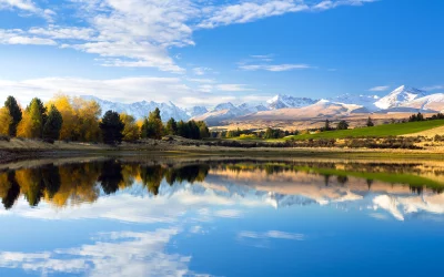 Vibrant Autumn Lake Reflecting Majestic Snow-Capped Mountains and Clear Blue Sky image