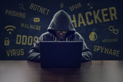 Anonymous Hacker Operating Laptop with Cyber Security Threat Warnings image