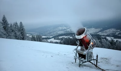 Snow Cannon on Snowy Mountain Slope with Winter Landscape and Frosted Forest image